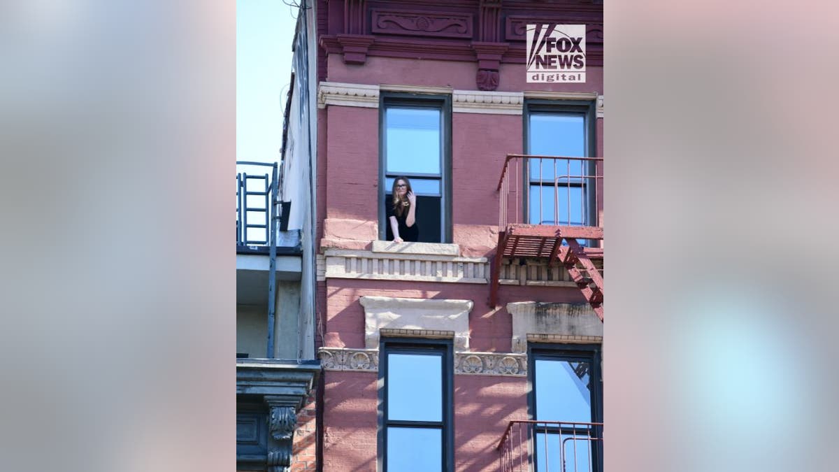 Newly released Anna Sorokin waves New York City Window