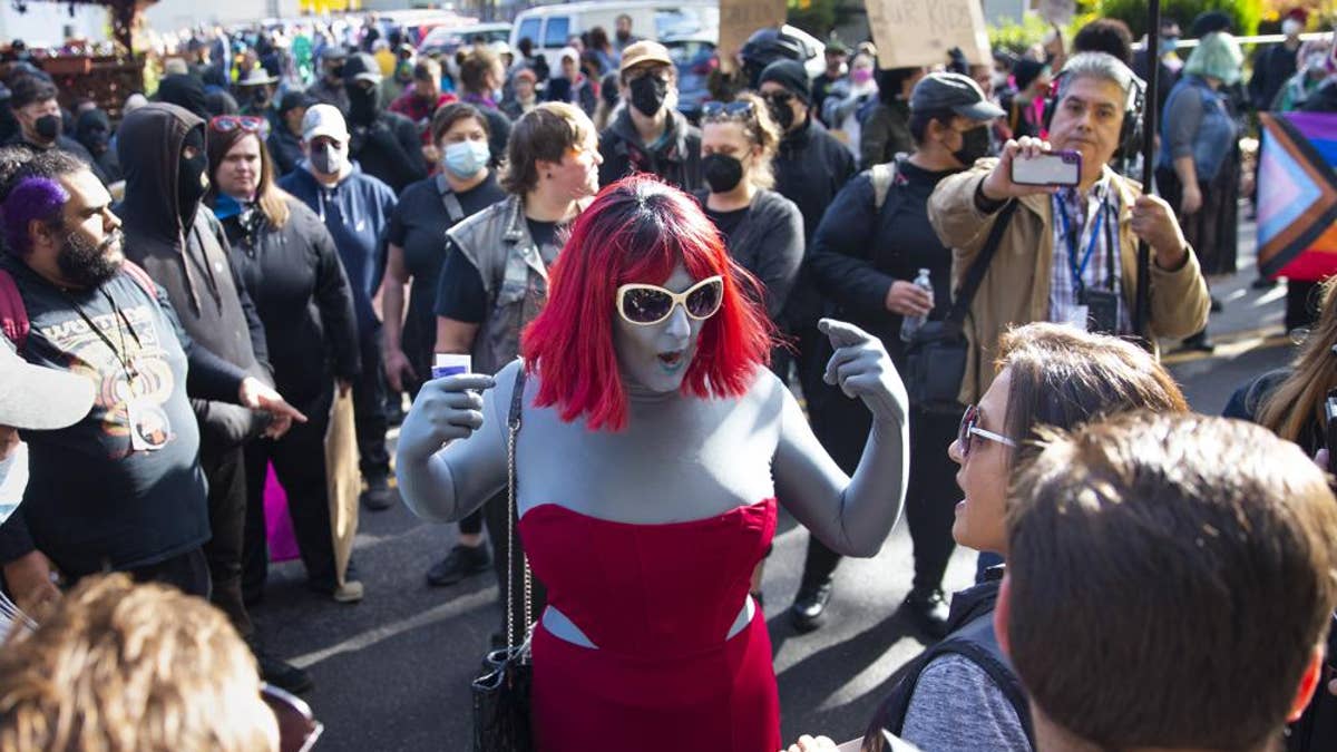 photo of drag queen, protesters