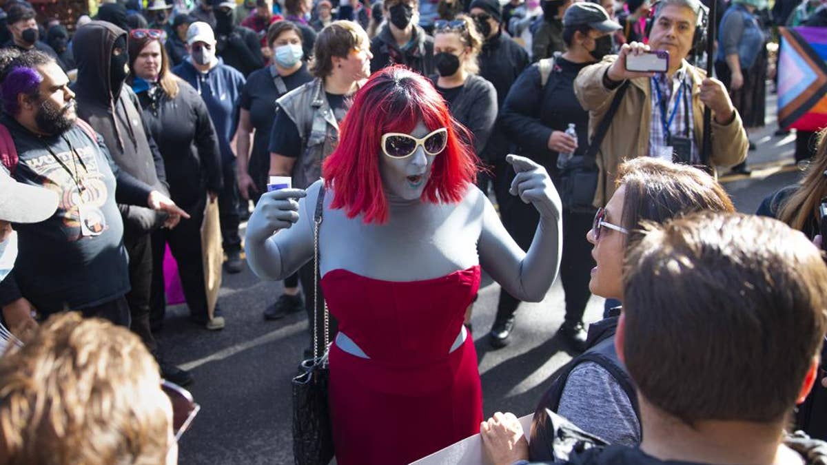 photo of drag queen, protesters