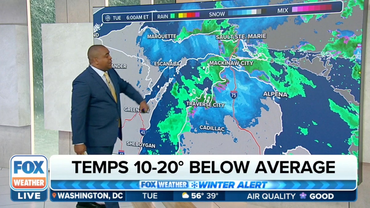 Fox Weather anchor stands in front of map showing cold temps