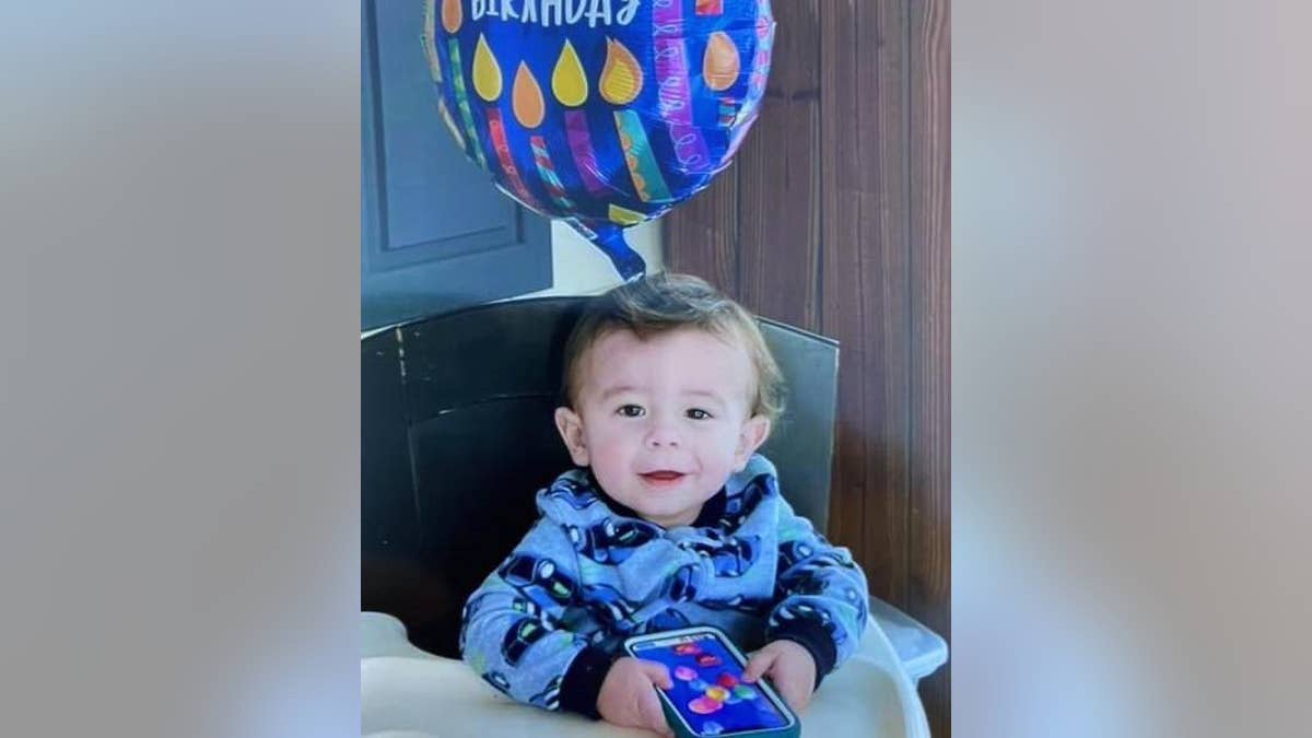 Quinton Simon smiling in front of a balloon