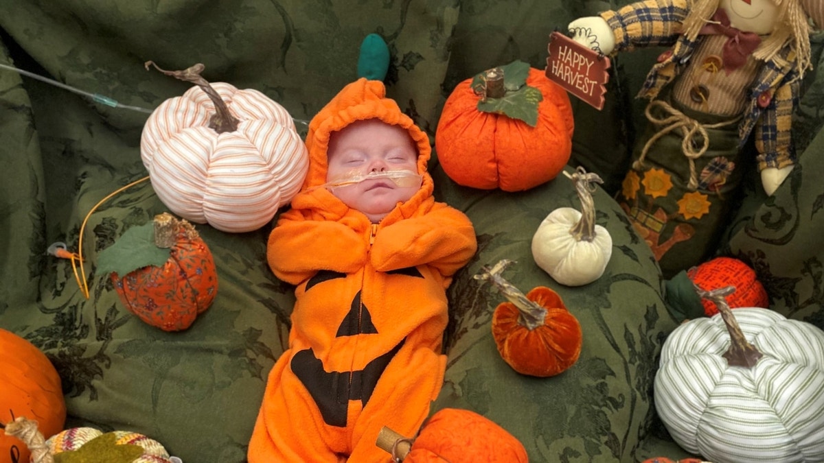 Sleeping infant dressed as a pumpkin