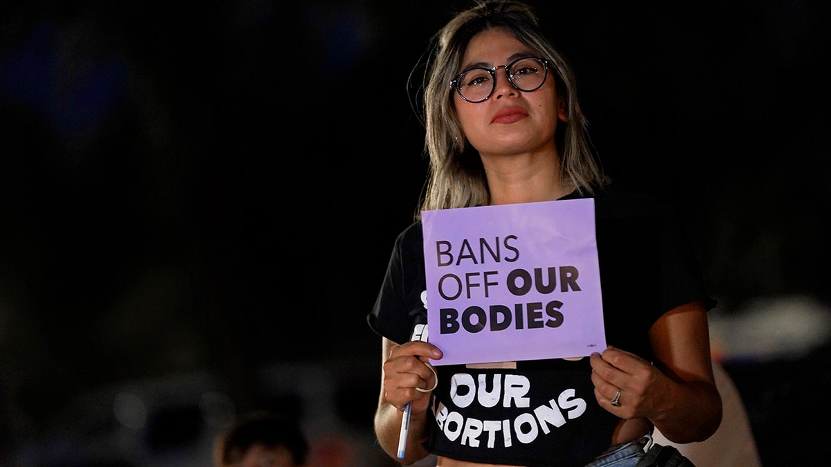 A woman holding an abortion sign