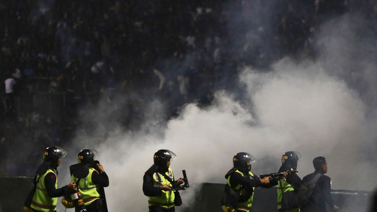 Police officers fire tear gas during a soccer match at Kanjuruhan Stadium in Malang, East Java, Indonesia, Saturday, Oct. 1, 2022.