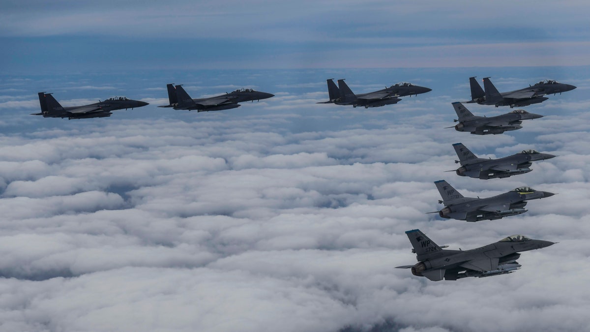 War planes fly in a triangle formation over clouds