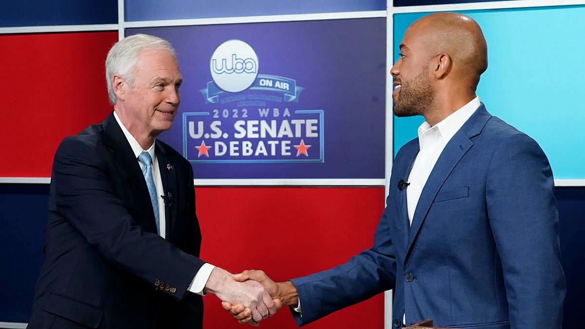 johnson shakes hands with barnes at wisconsin debate
