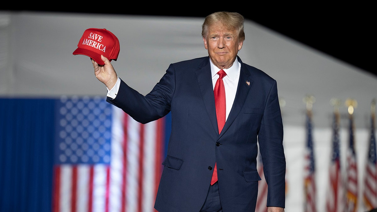 Trump holding a MAGA hat