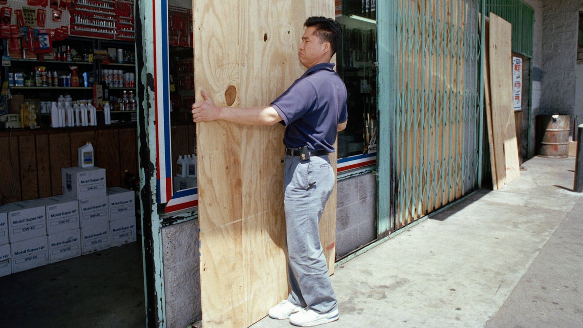 Man takes down protective boards outside his store