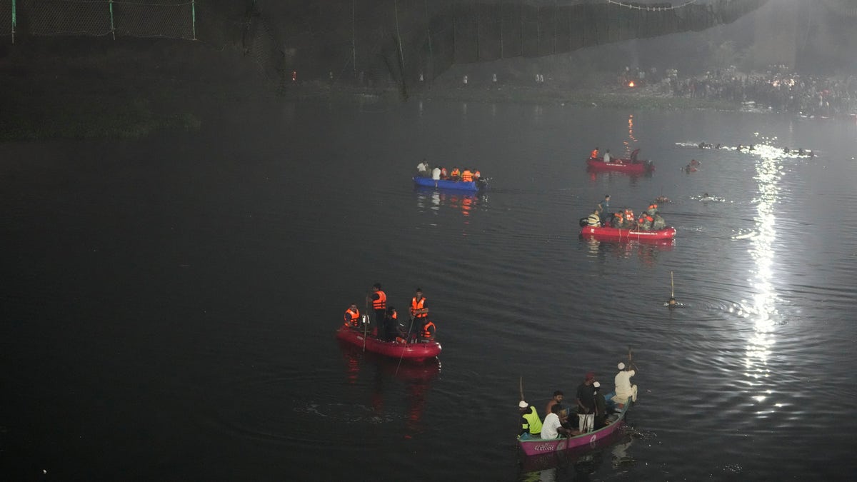 Colorful boats in the river as they search for survivors of a bridge collapse in India
