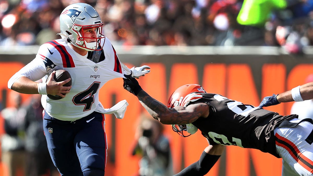 New England Patriots quarterback Bailey Zappe avoids a sack by Cleveland Browns' Grant Delpit.