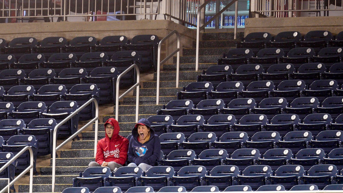 Two fans sit and watch Washington Nationals game