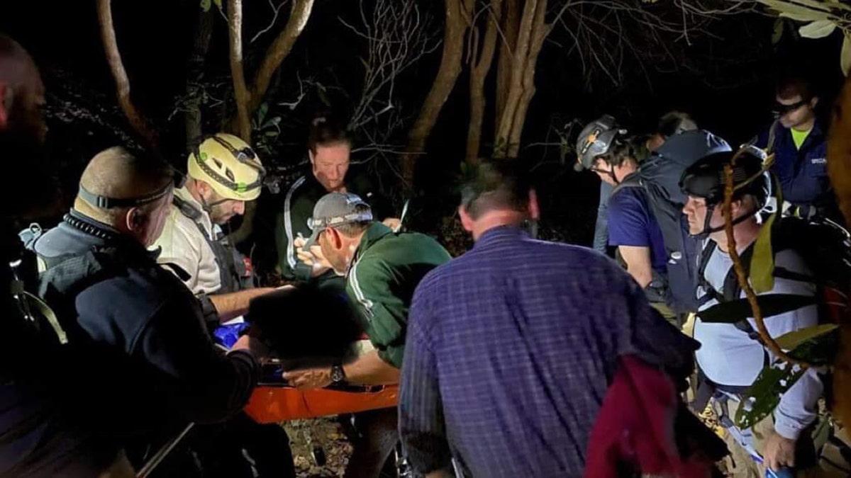 rescuers treating hiker on trail