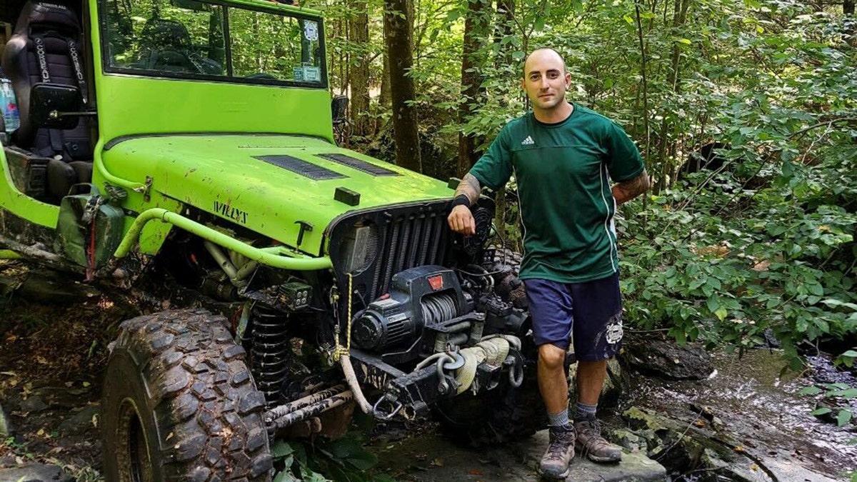 TJ Foley poses next to Jeep