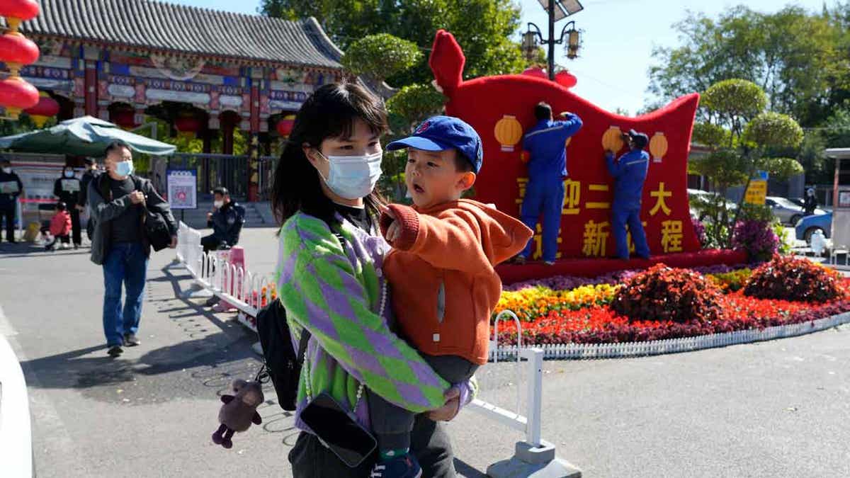 Woman with a mask holding her child in China