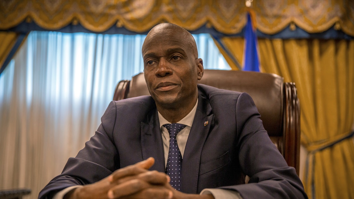 The former president of Haiti looks on