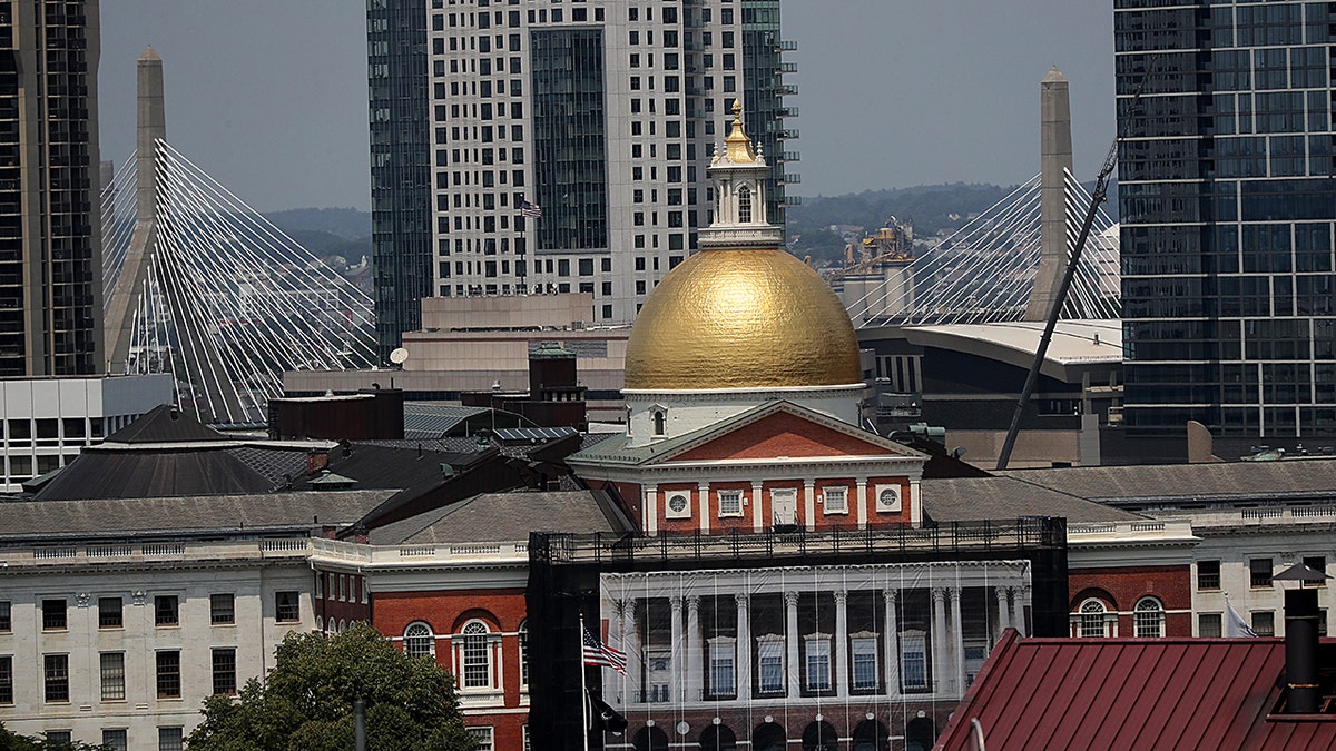 state house in Boston with skyscrapers, bridge behind it