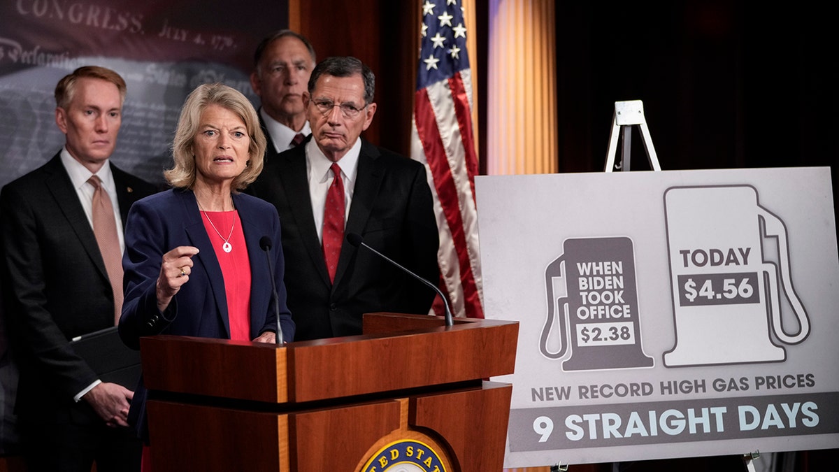 Lisa Murkowski behind a podium speaking to reporters