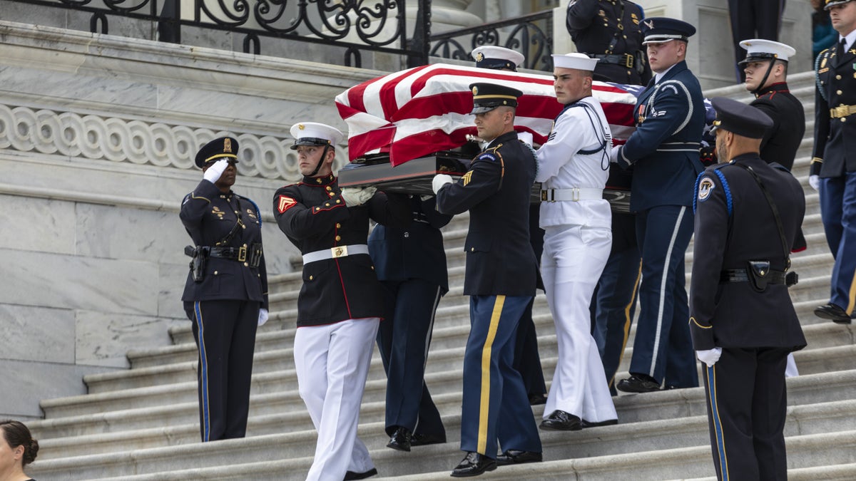 coffin draped in flag carried out