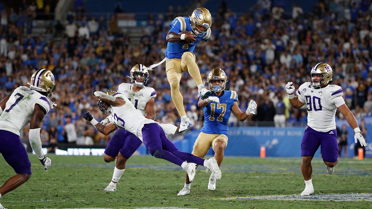 Dorian Thompson-Robinson leaps over a Washington defender