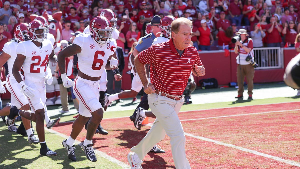 Nick Saban and players running onto field