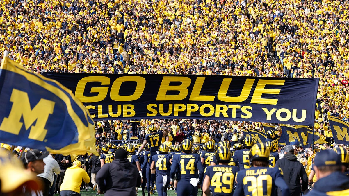 The Michigan Wolverines run onto the field