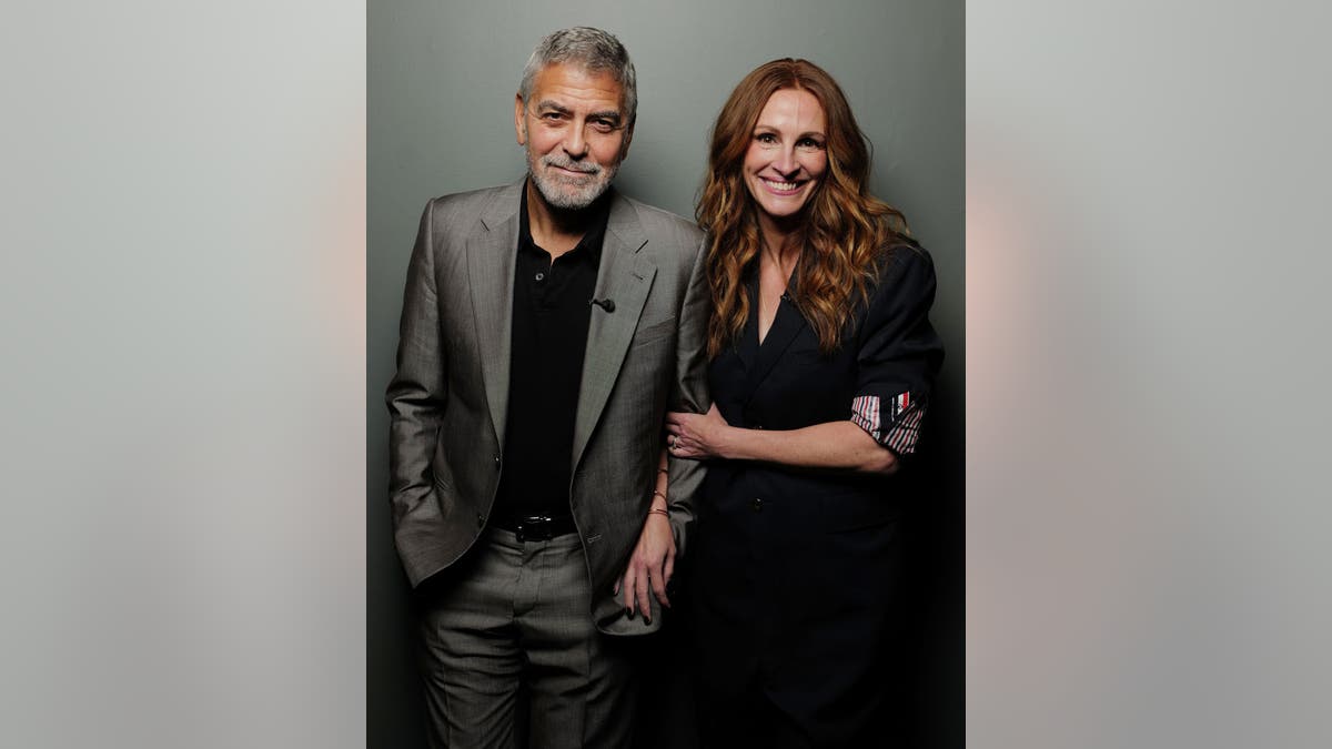 julia roberts george clooney pose for a photo next to each other