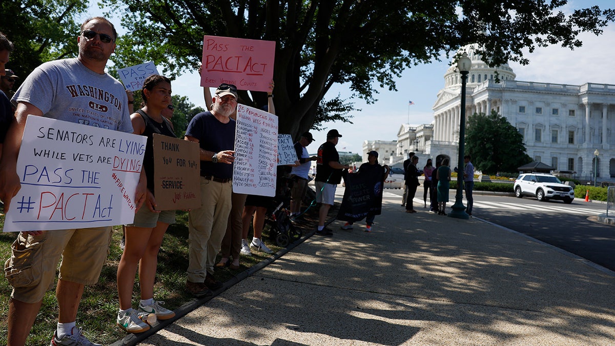 Veterans, supporters rally outside the U.S. Capitol Building holding signs promoting the PACT Act