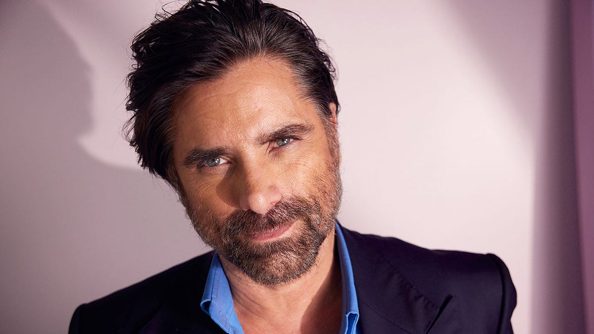 John Stamos poses for a photo