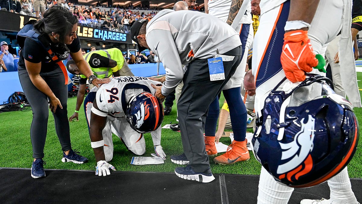 Aaron Patrick kneels in pain after colliding with sideline staff member