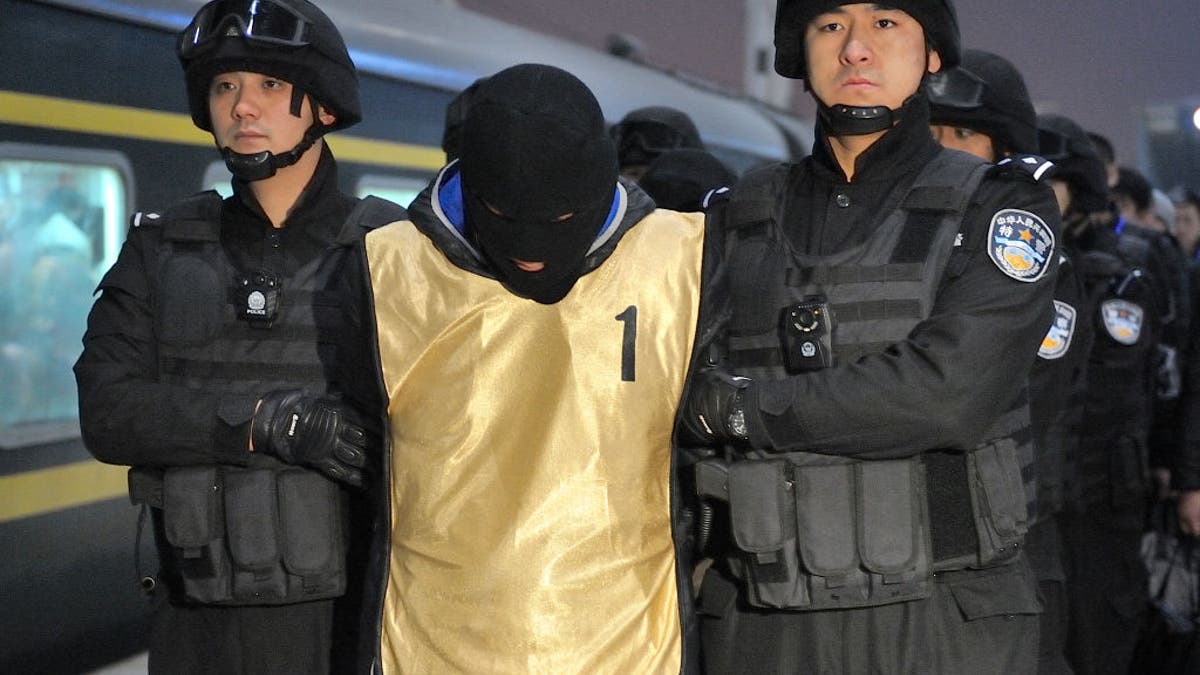 Chinese police haul away a suspect