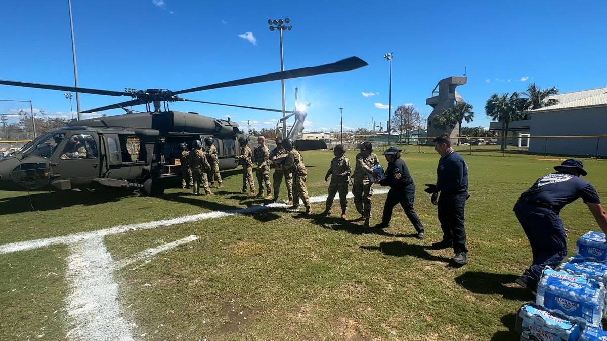 National Guard members load up a helicopter with supplies to be delivered to victims of Hurricane Ian