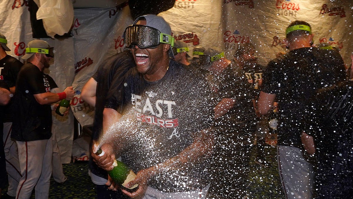 Atlanta Braves left fielder Guillermo Heredia, center, celebrates in the clubhouse after Atlanta clinched its fifth consecutive N.L. East title by defeating the Miami Marlins on Oct. 4, 2022, in Miami.