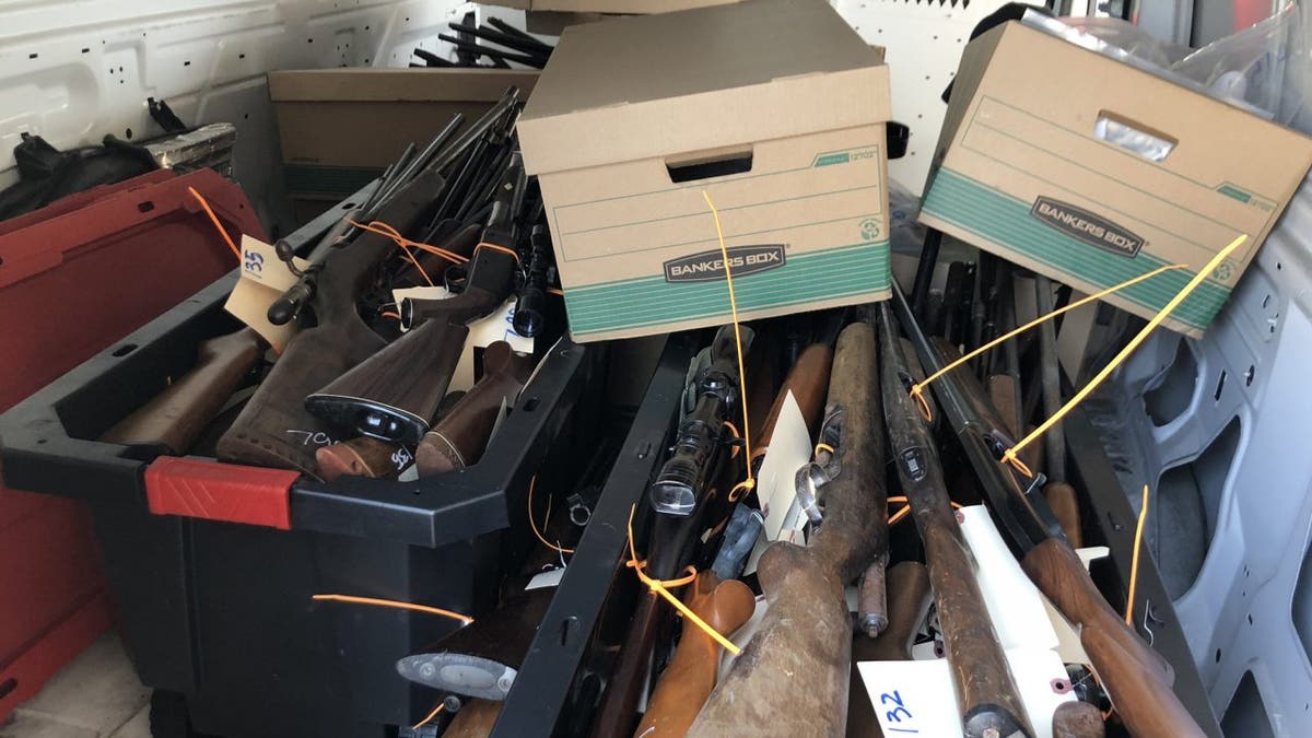 Guns and boxes sit in a bin