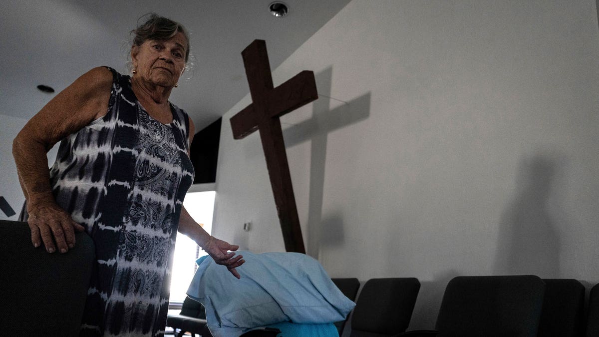Lady setting up a makeshift bed inside of a church