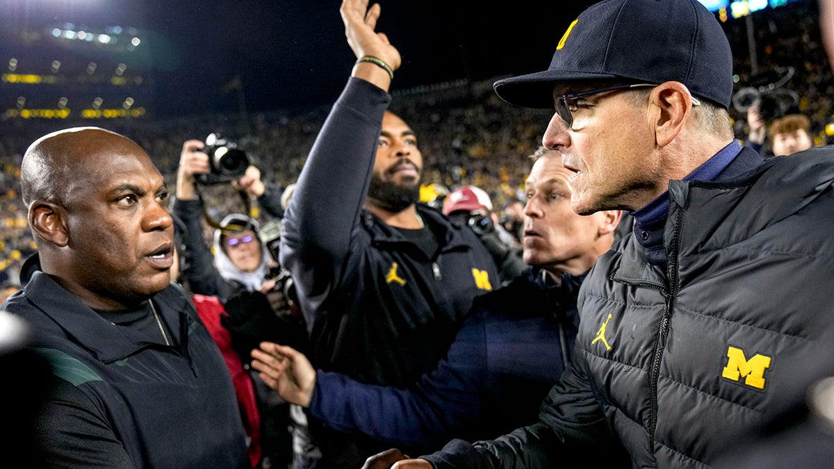 Jim Harbaugh shakes hands with Mel Tucker