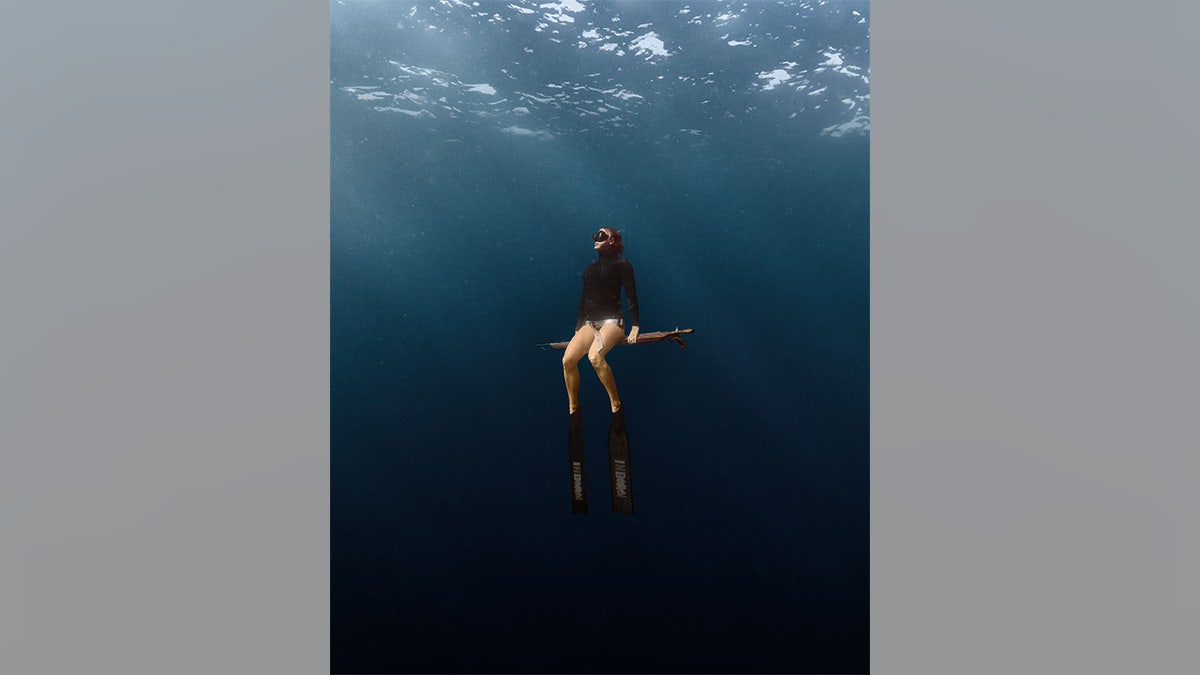 Julie Augustine poses with polespear underwater