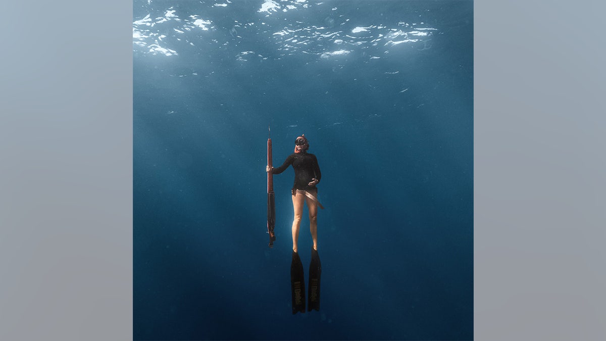 Julie Augustine underwater with polespear
