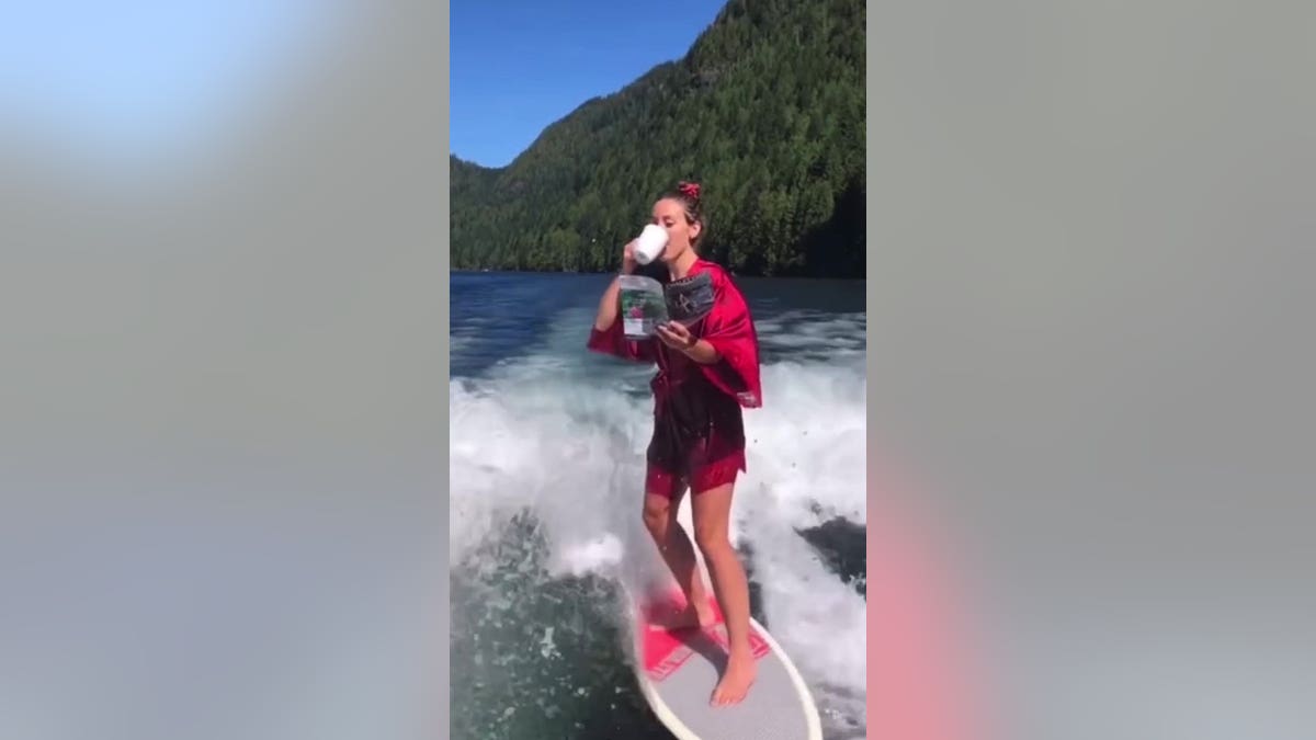 Cassandra Lee wakesurfing while sipping coffee