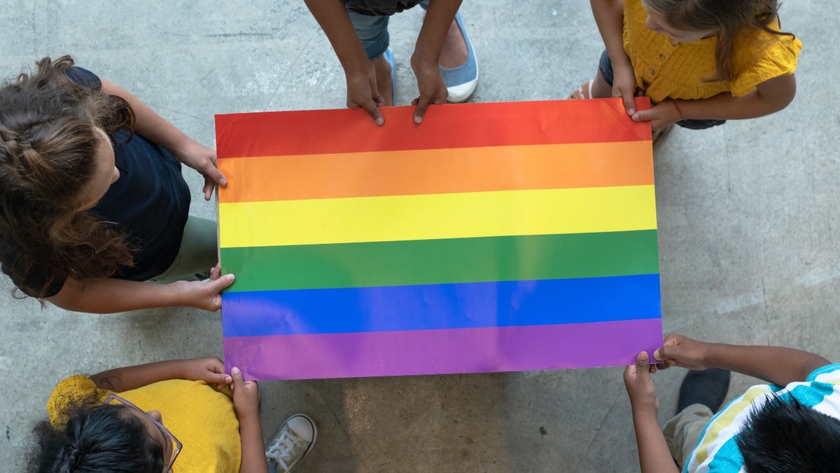 Elementary school students with Gay Pride flag