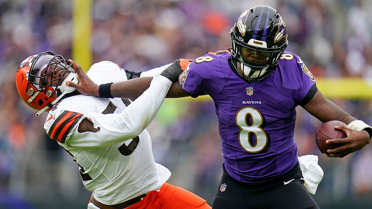 Lamar Jackson stiff arms Browns player