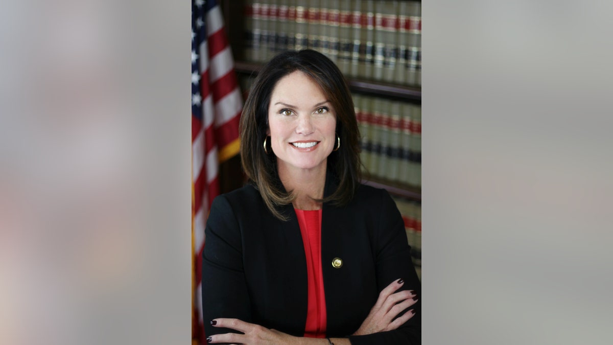 Headshot of Melissa Nelson posing beside an America flag