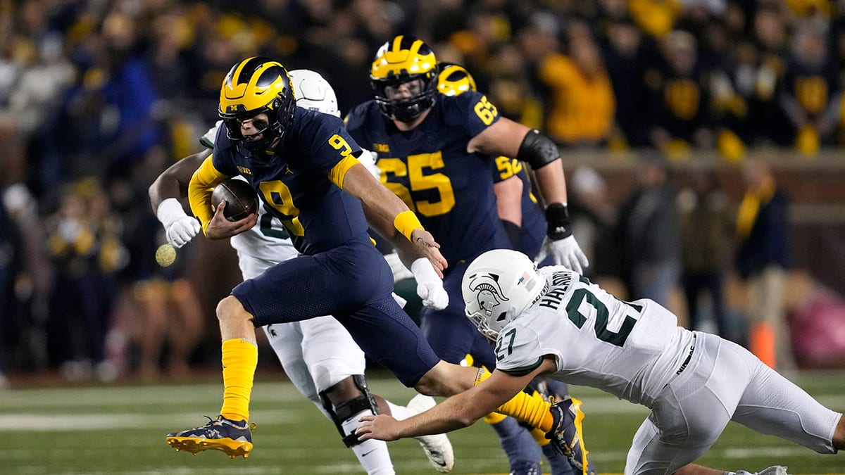 J.J. McCarthy runs from Michigan State defender