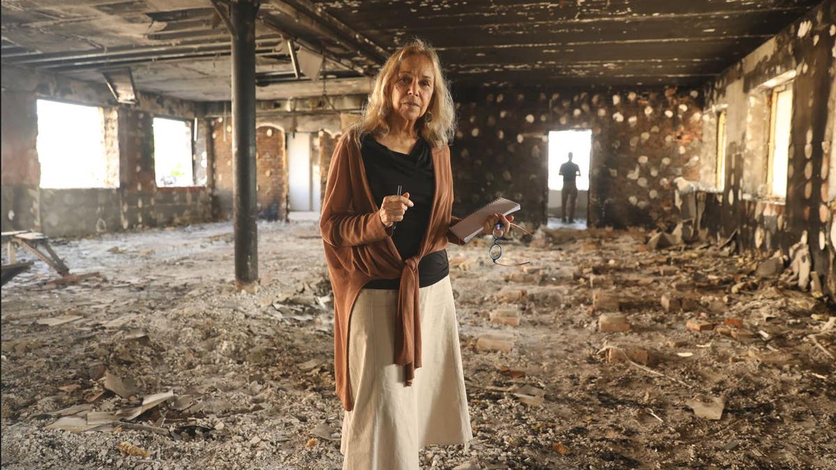 Mitzi Perdue in front of a bombed-out police station. 