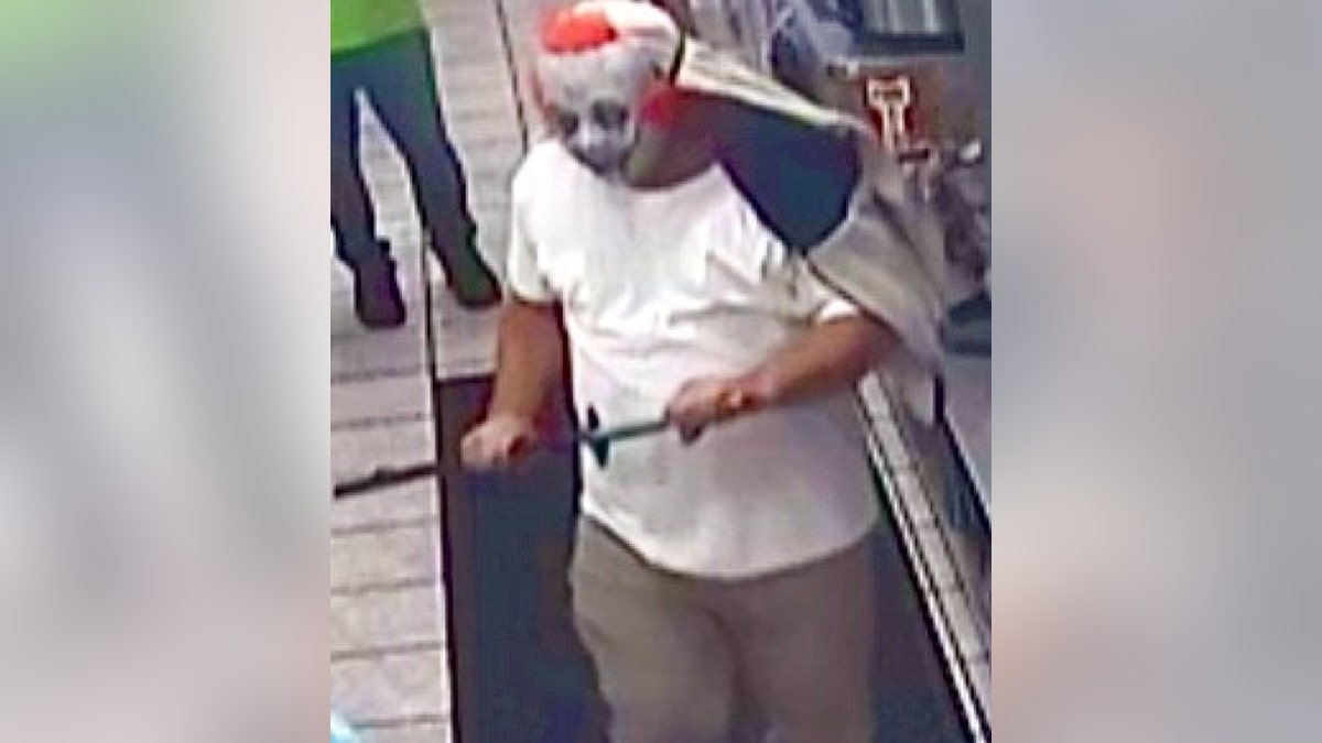 robbery suspect in clown mask and holding samurai sword