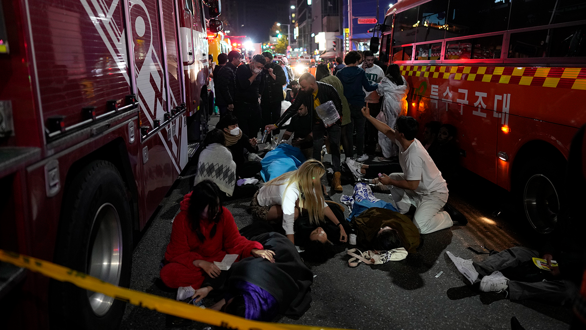 People helping victims of the Halloween crowd surge in Seoul, South Korea