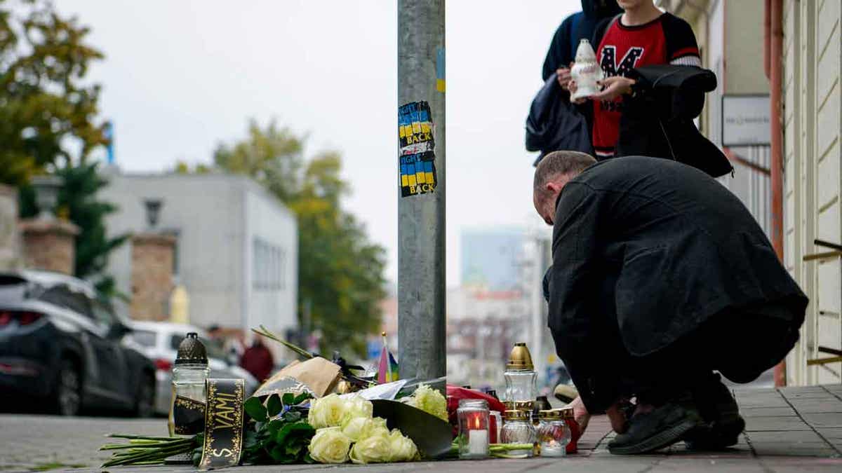 People lay flowers and light candles in Bratislava, Slovakia