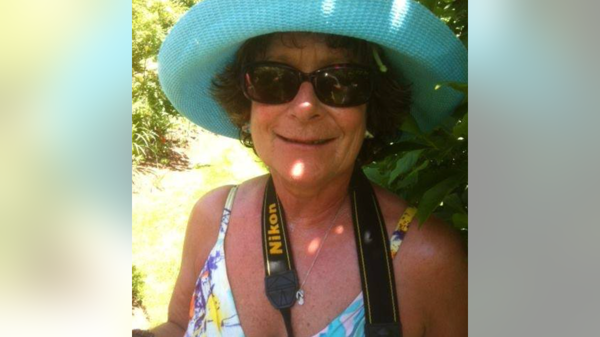 Susan Howe, wearing a blue hat, and smiling