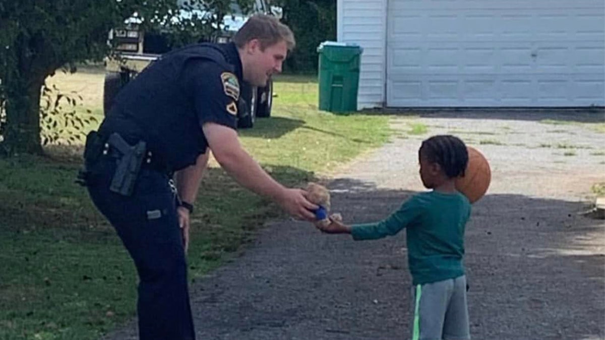 Deputy hands stuffed animal to child