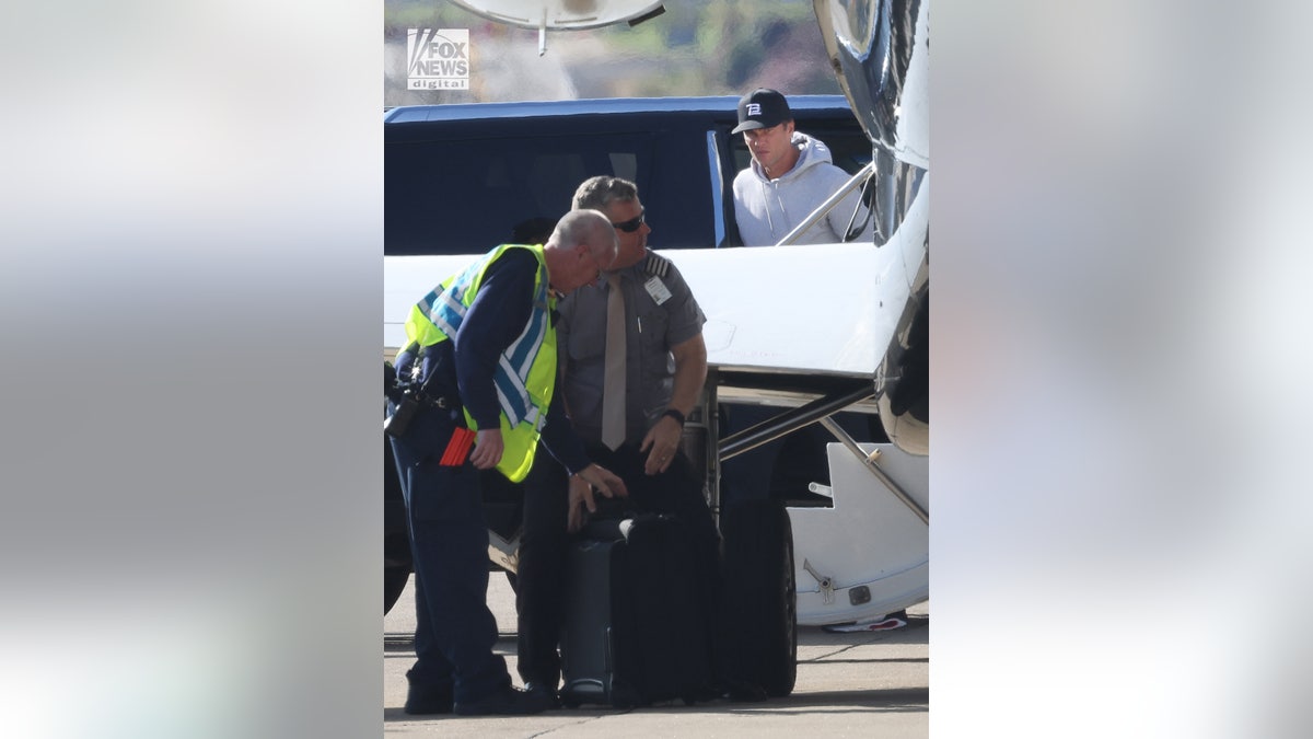 Tom Brady walks off the plane