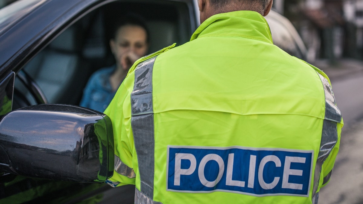 Traffic police officer talking to a woman in her car